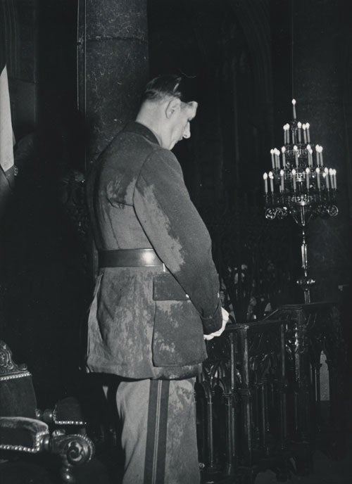 Item #232457 Photograph of a rain-soaked Charles de Gaulle praying in the Cathedral of Notre Dame, Nice, 1948. Charles De Gaulle, Dmitri Kessel, photographer.