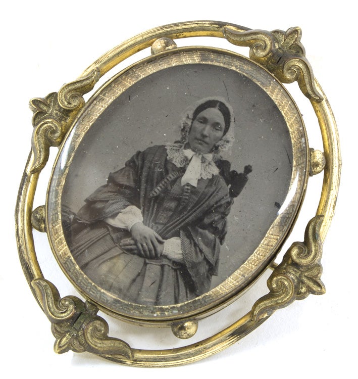Tintype and albumen portrait photographs of a women housed in a double-sided brooch