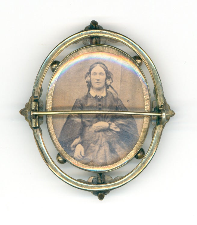 Tintype and albumen portrait photographs of a women housed in a double-sided brooch